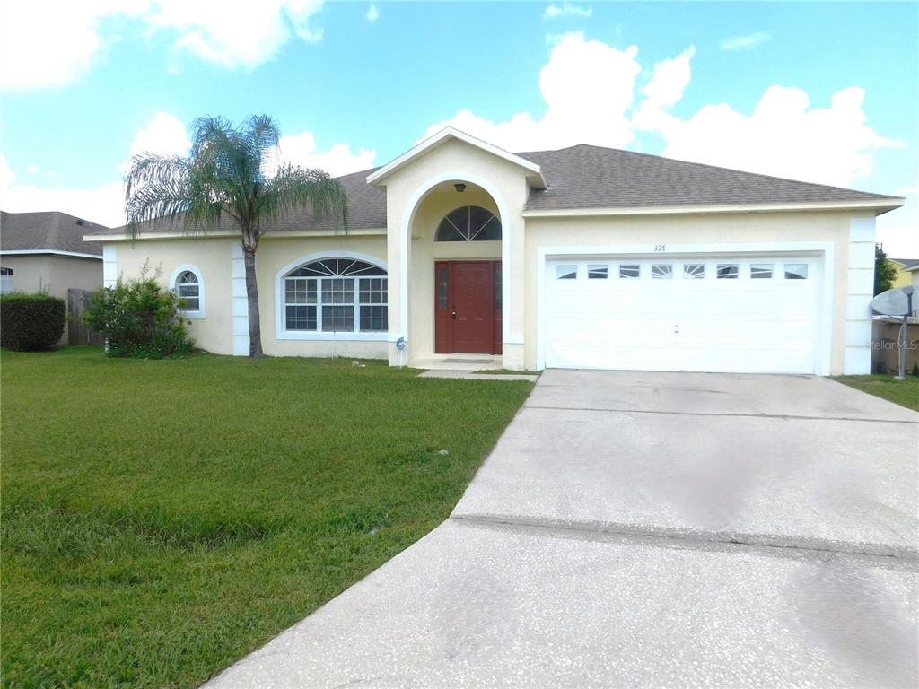 a front view of a house with yard and green space