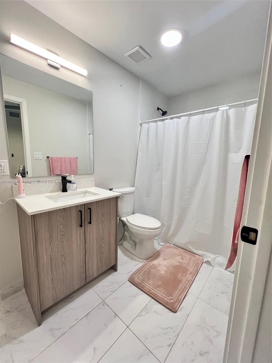 a bathroom with a double vanity sink toilet and a mirror