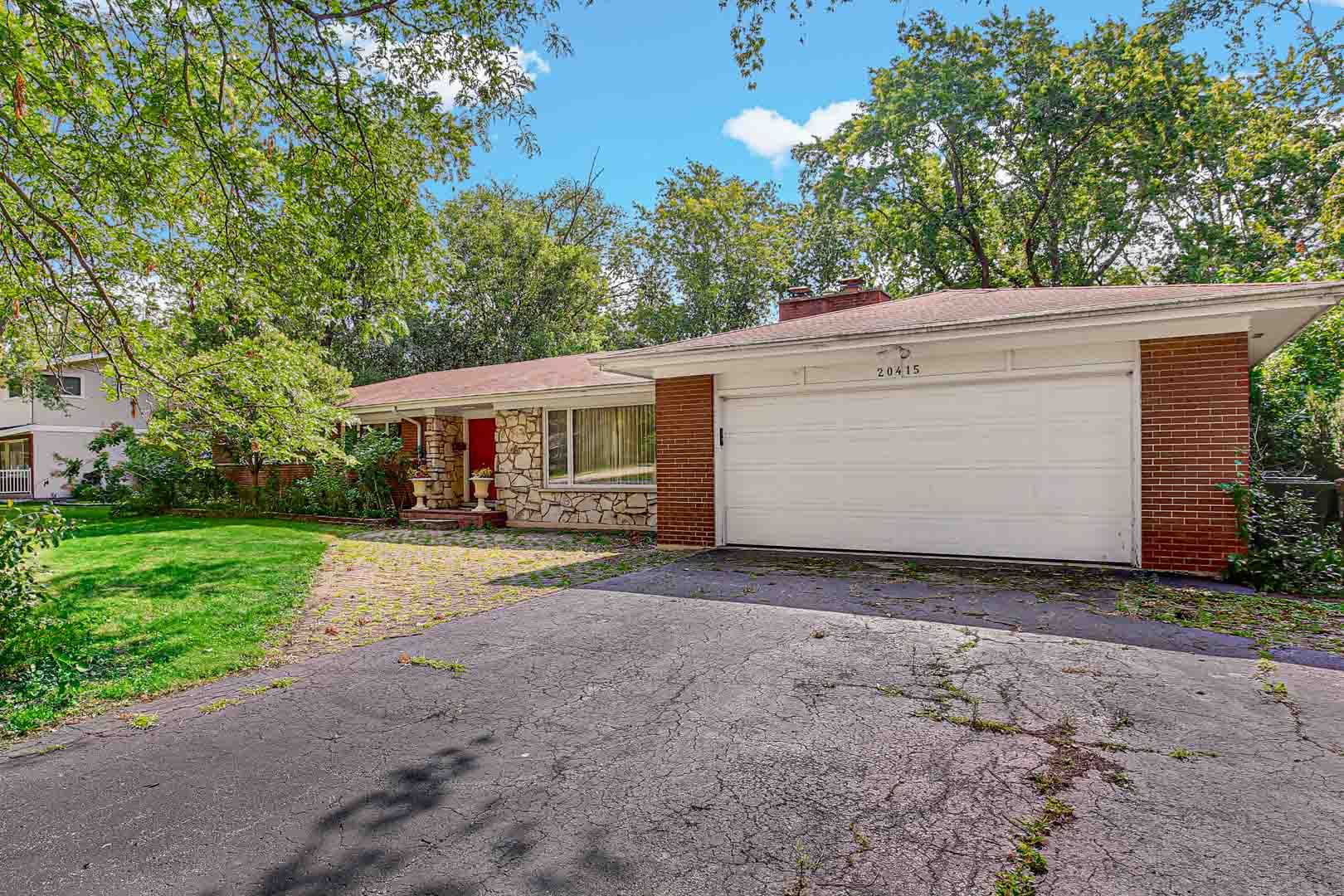 a front view of house with yard and trees