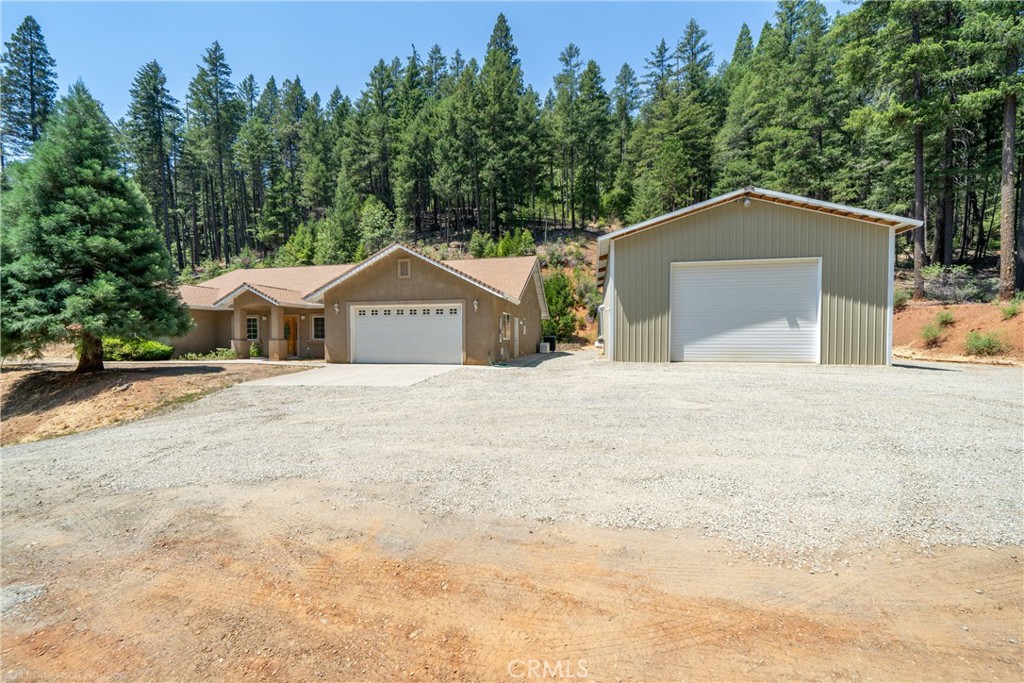 a front view of a house with a yard and trees