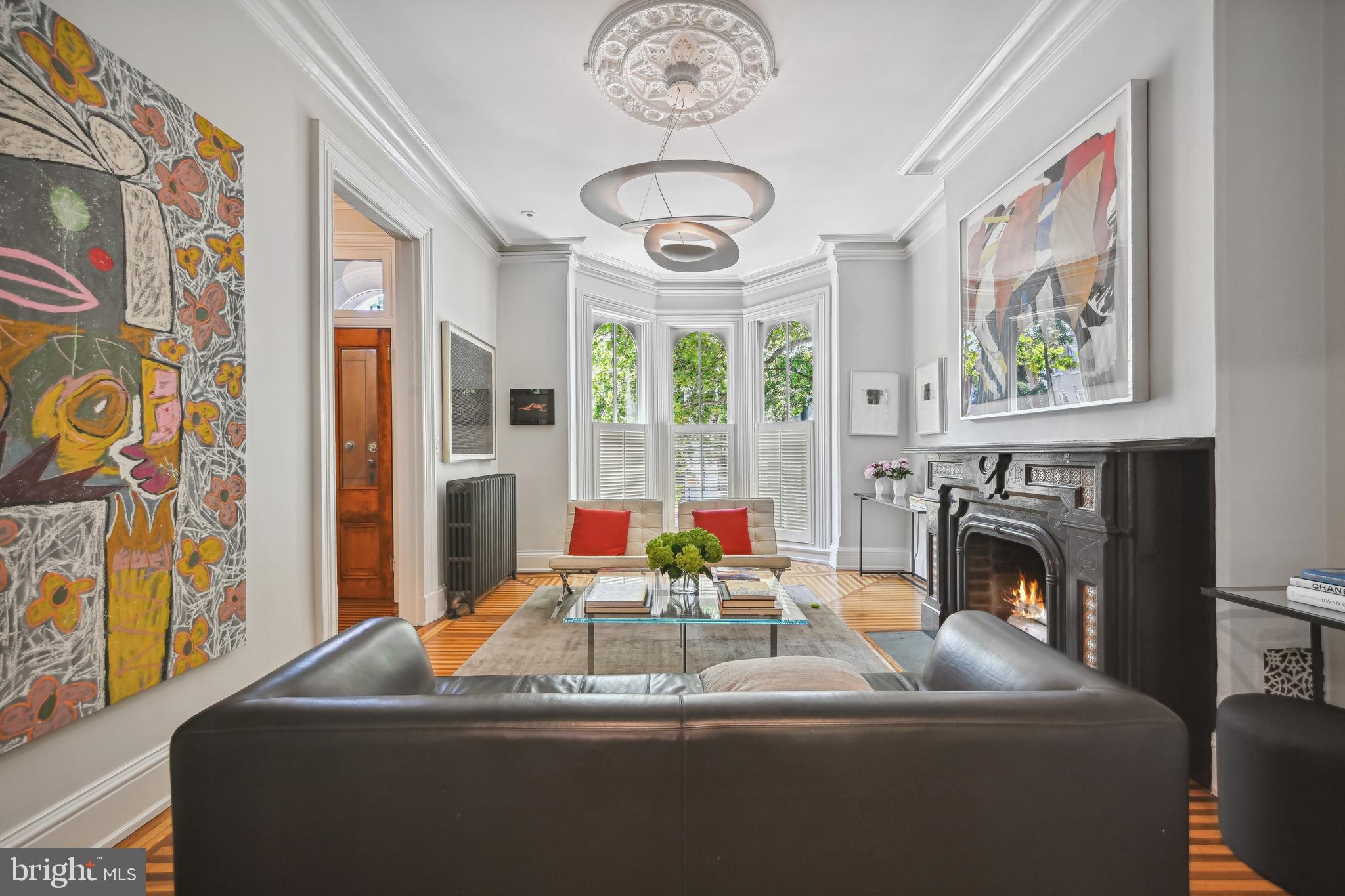 a living room with fireplace furniture and a large window