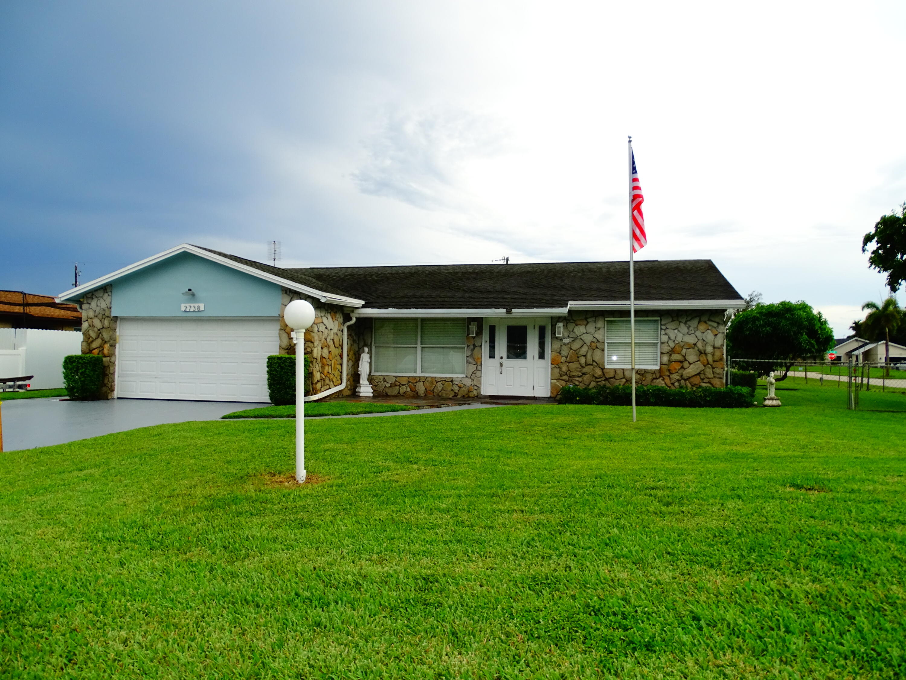 a front view of house with a garden