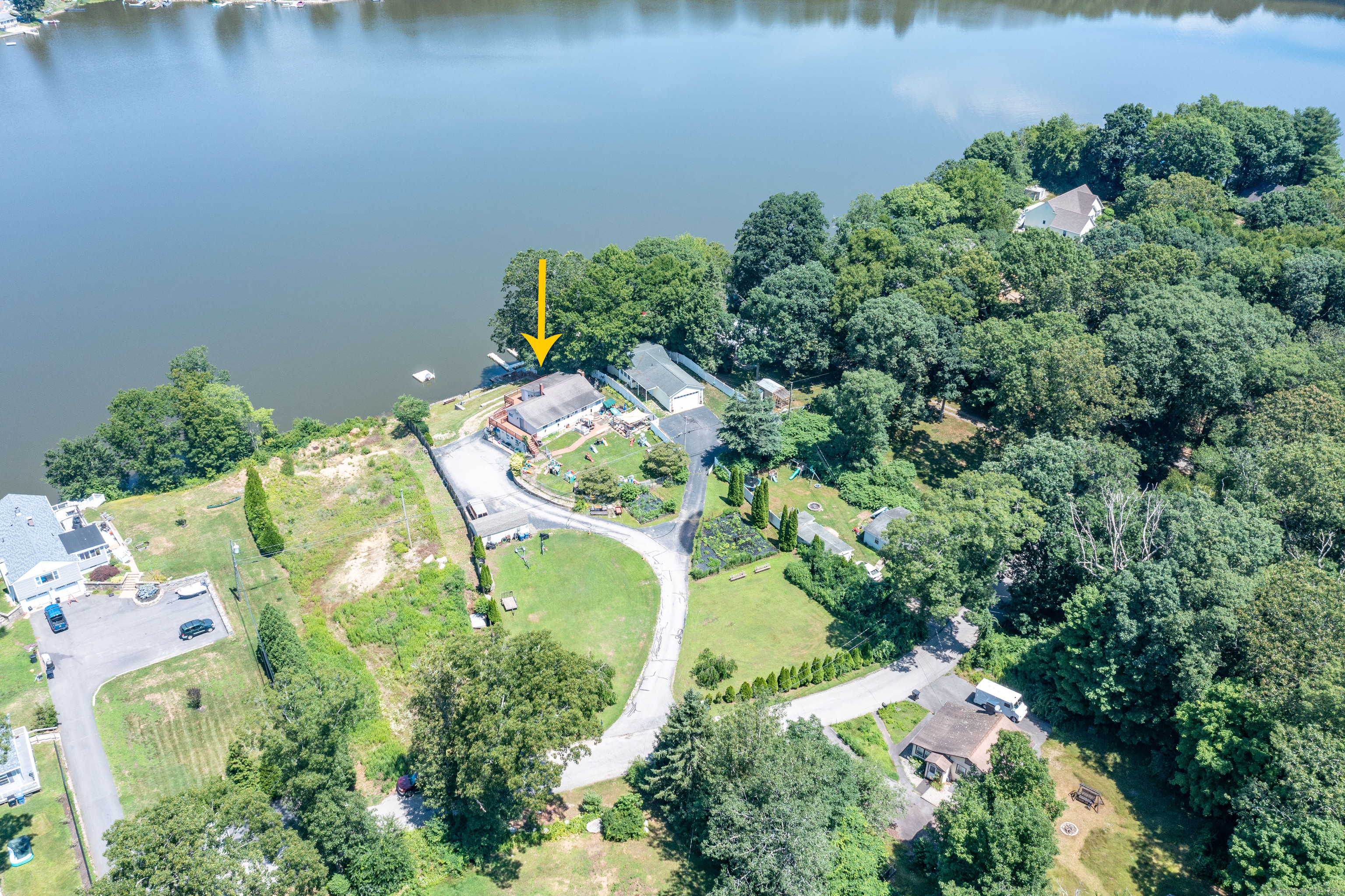 an aerial view of a house with a yard and lake view