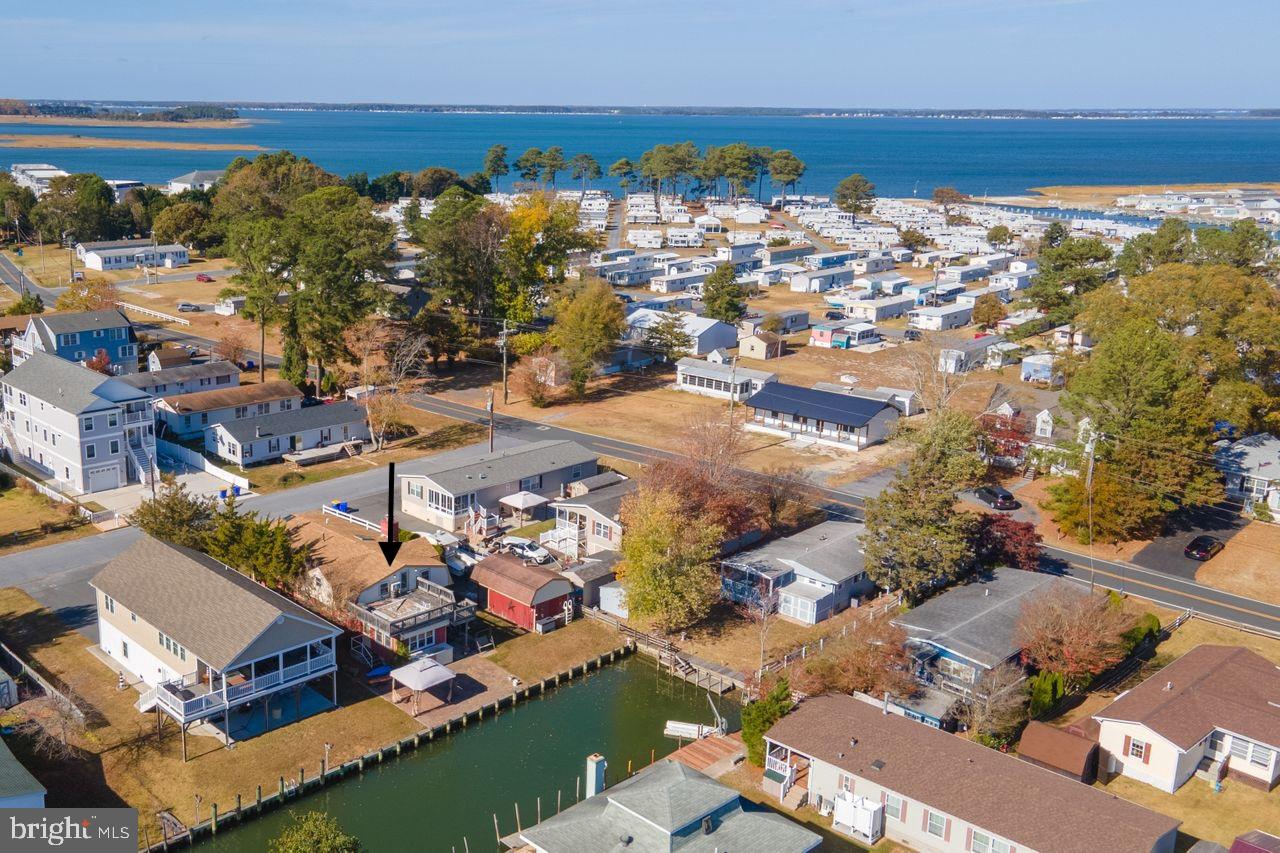 an aerial view of ocean and residential houses with outdoor space