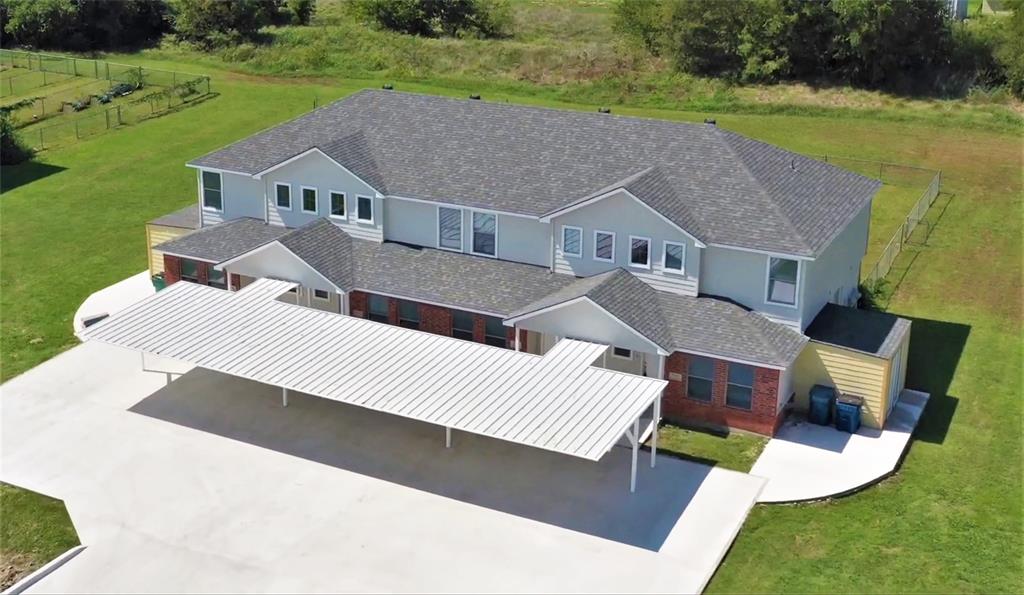 a aerial view of a house with garden space and a patio