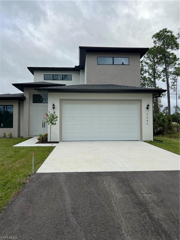 a front view of a house with a yard and garage