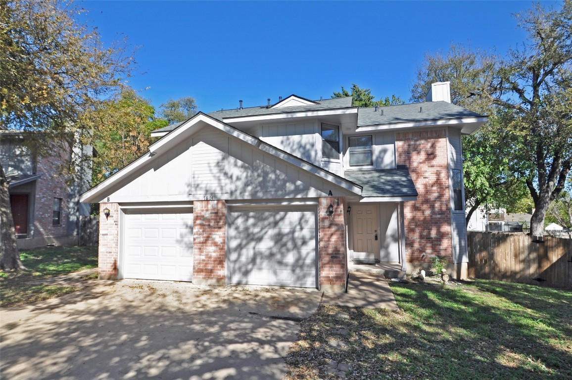 a view of a house with a yard and a garage