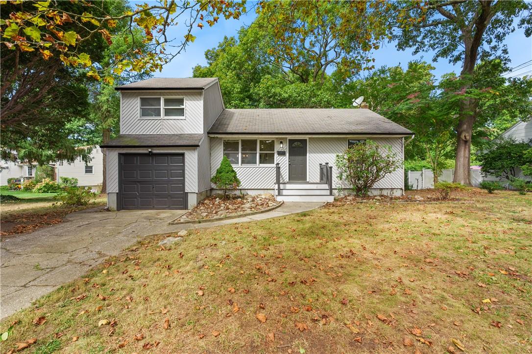 View of front of home with a garage and a front yard