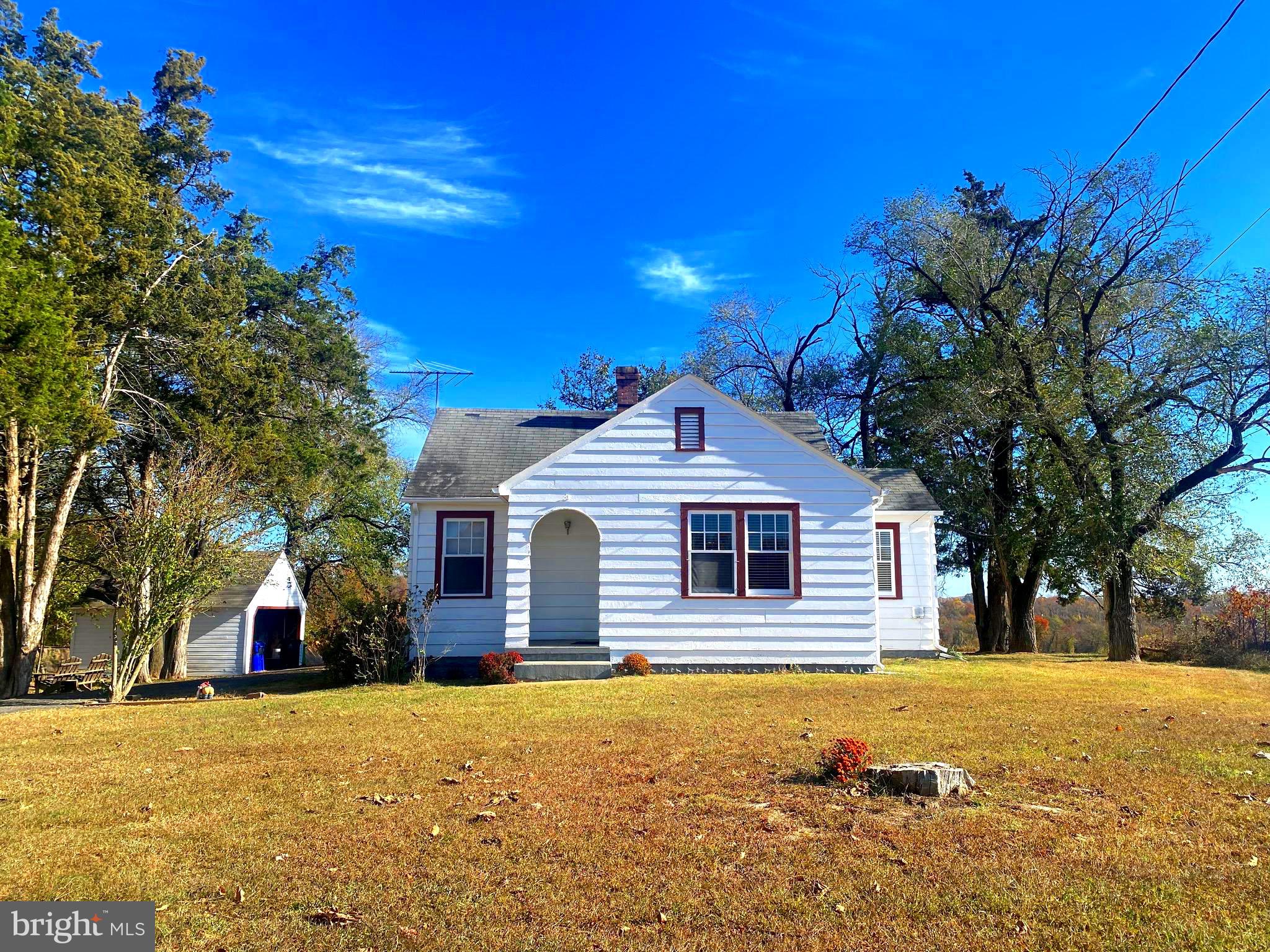 a front view of house with yard and trees around