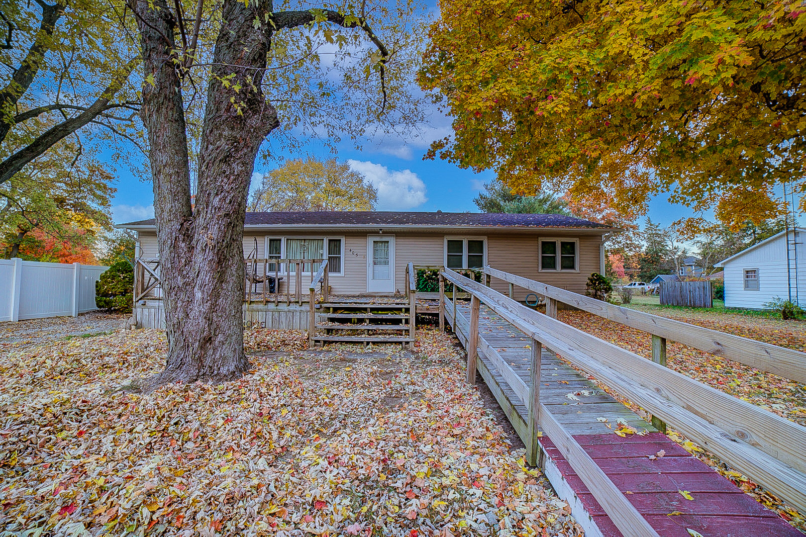 a view of house with outdoor seating and covered with trees