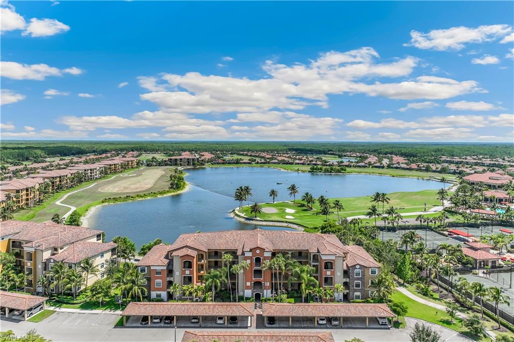 an aerial view of residential houses with outdoor space and lake view in back