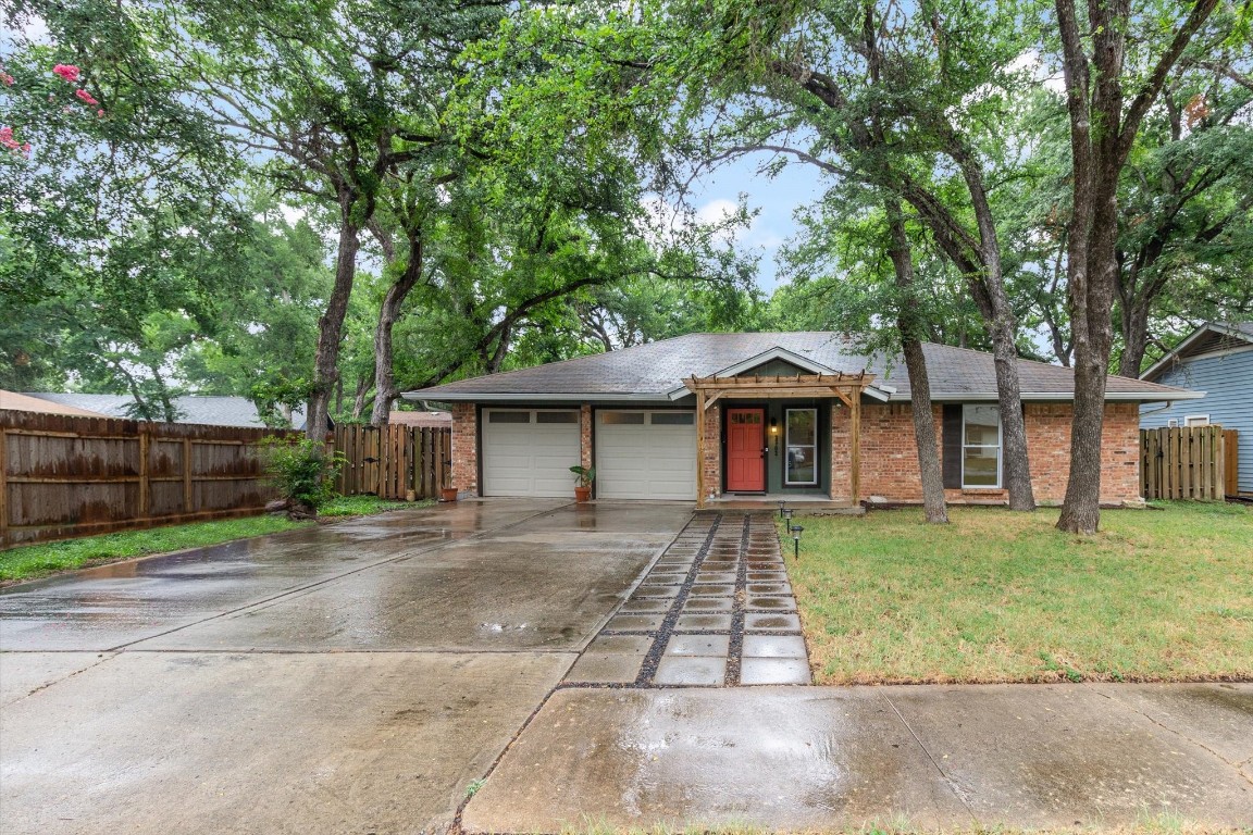 a front view of a house with a yard and trees