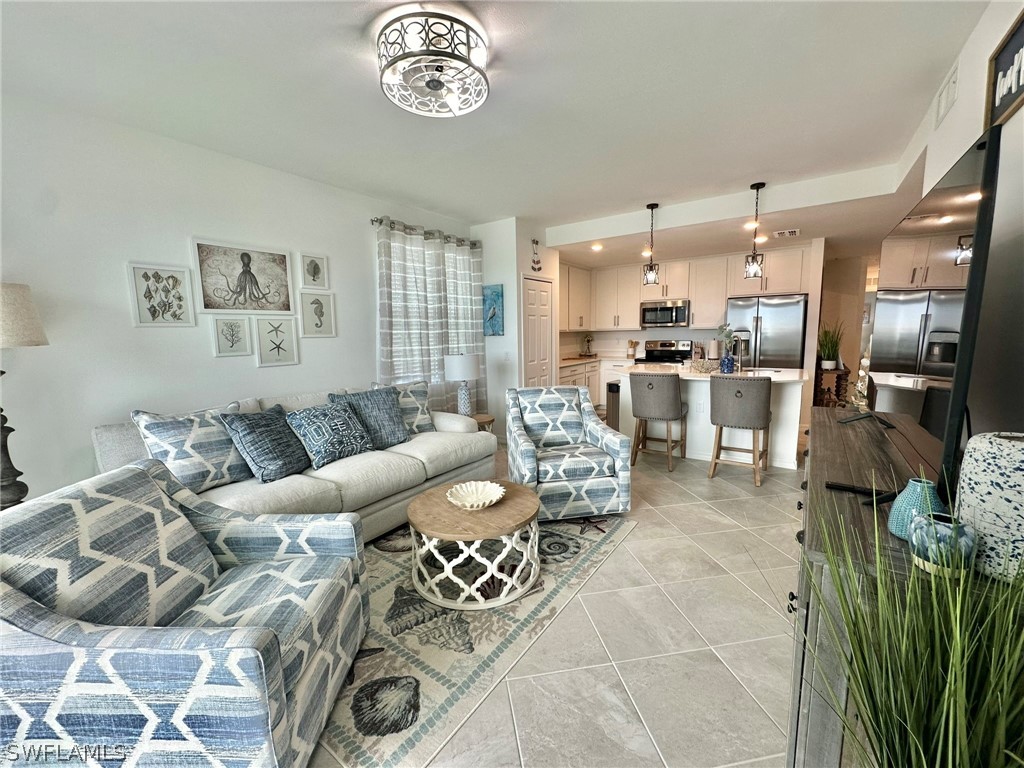 a living room with furniture kitchen view and a large window