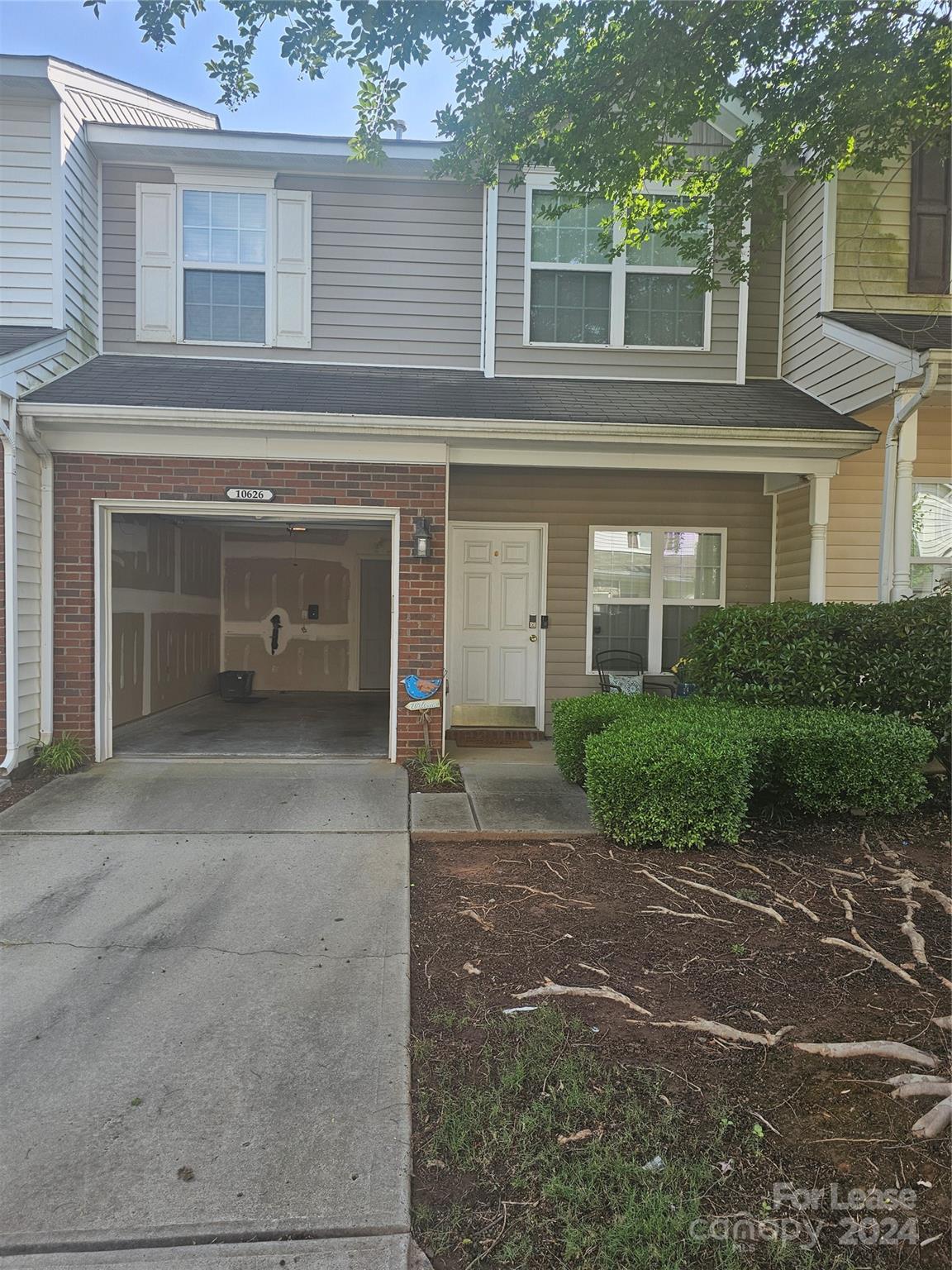 a front view of a house with a yard and a garage