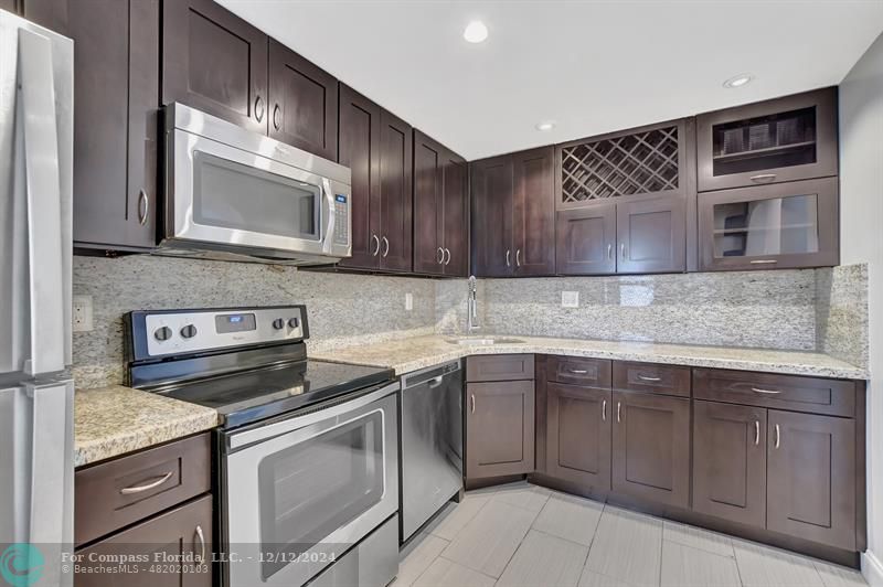 a kitchen with stainless steel appliances granite countertop a stove microwave and oven