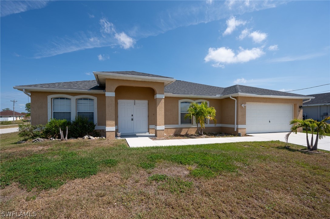 a front view of a house with a garden and yard