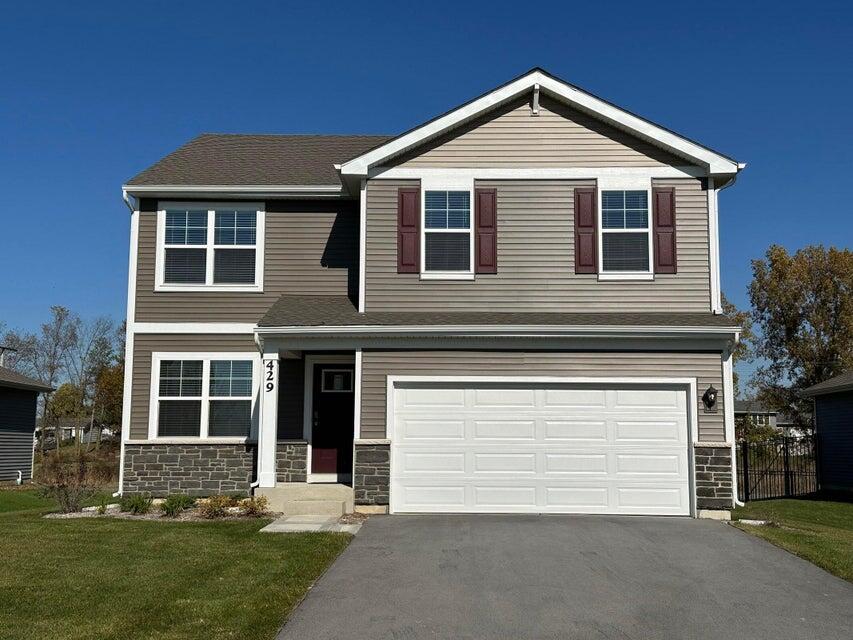 a front view of a house with a yard and garage