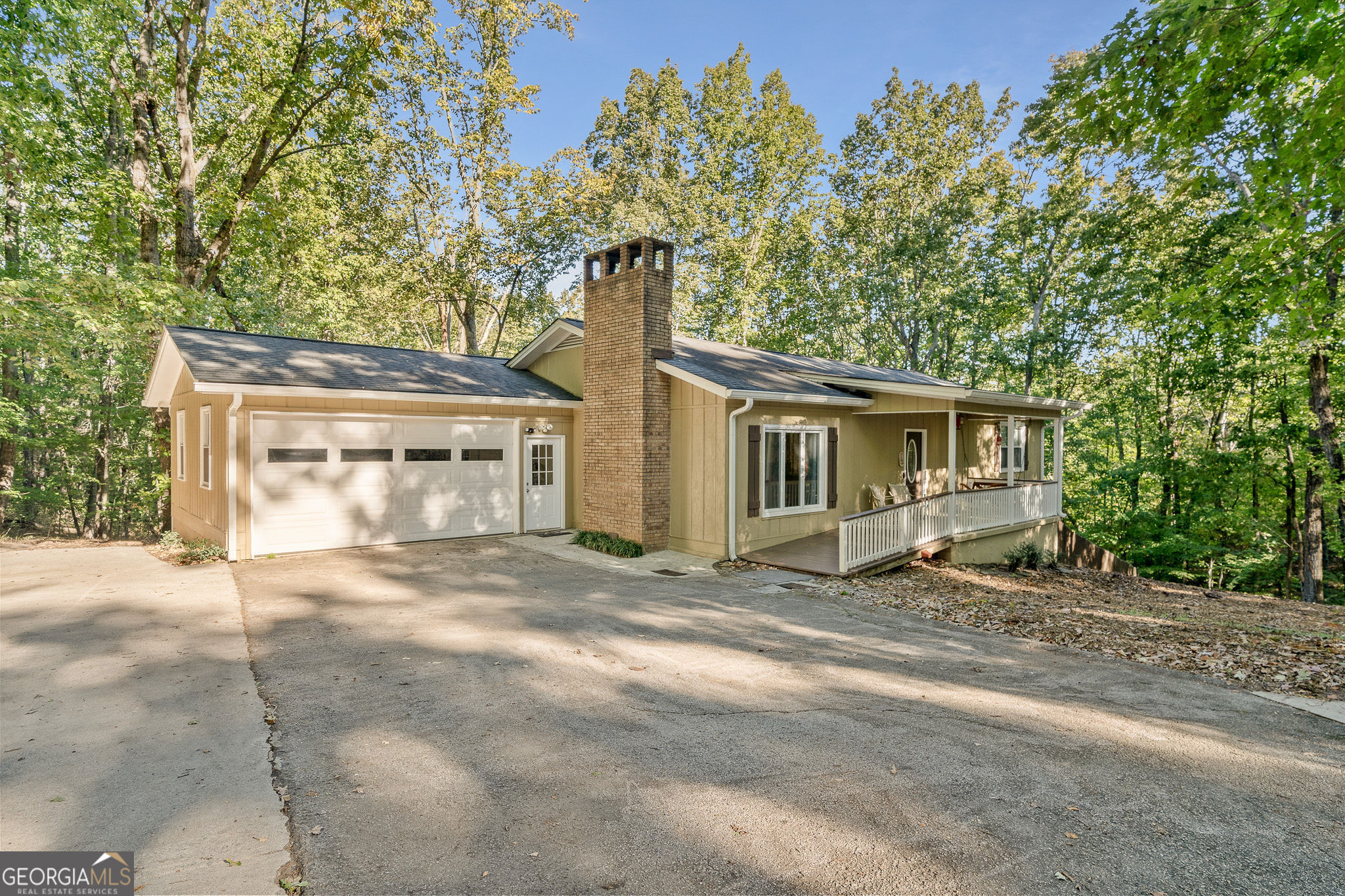 a front view of a house with a garden and trees