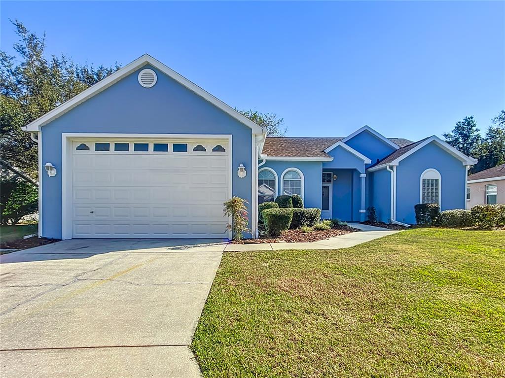 a view of a house with yard and garage