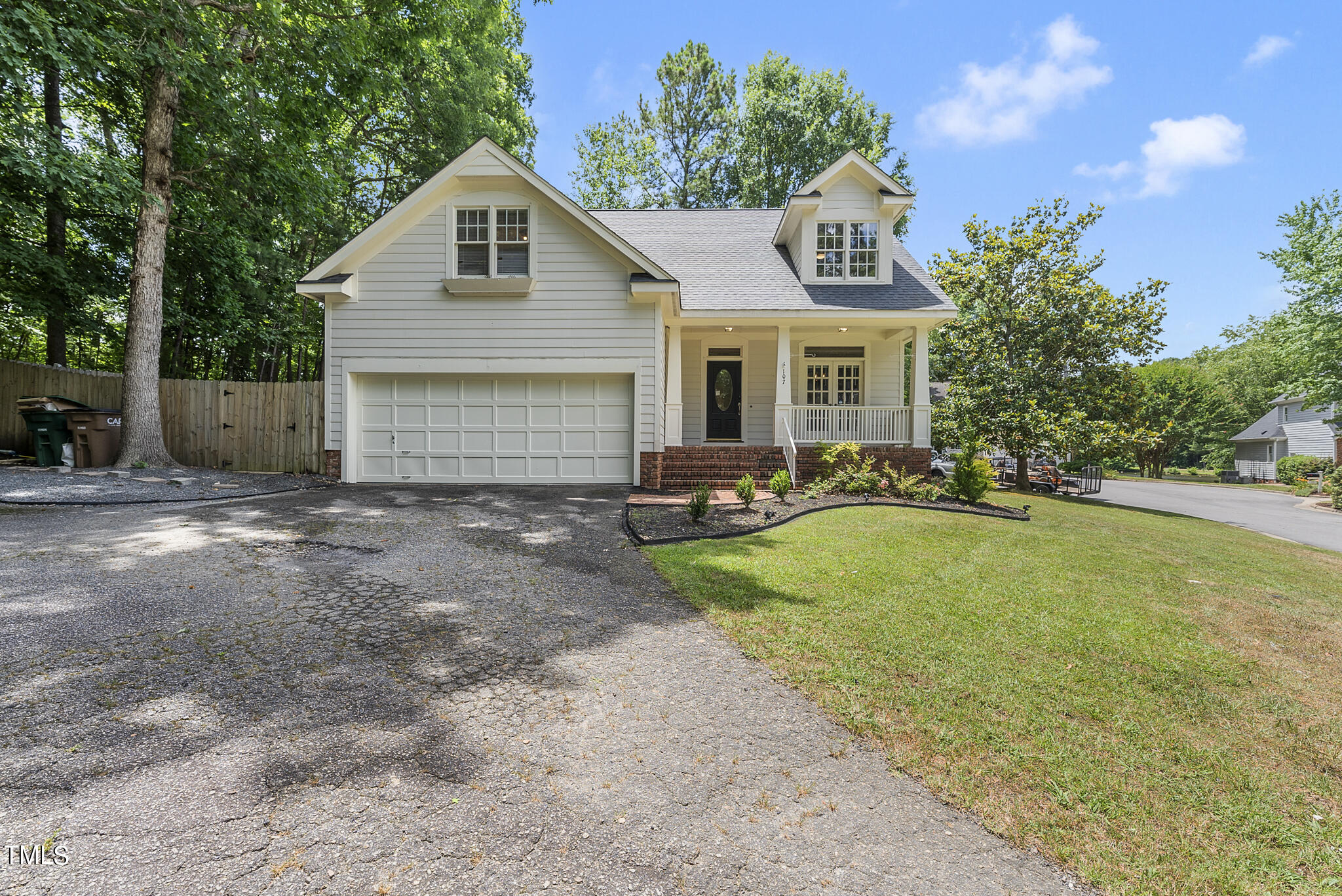 a front view of house with yard and trees in the background