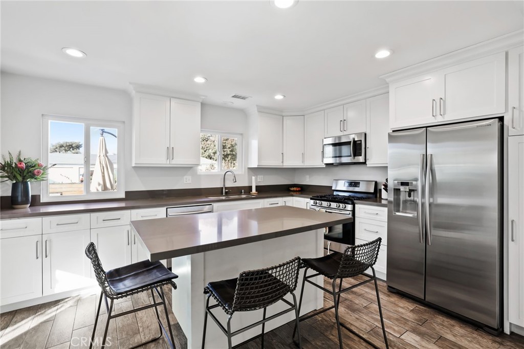 a kitchen with a table chairs refrigerator microwave and cabinets