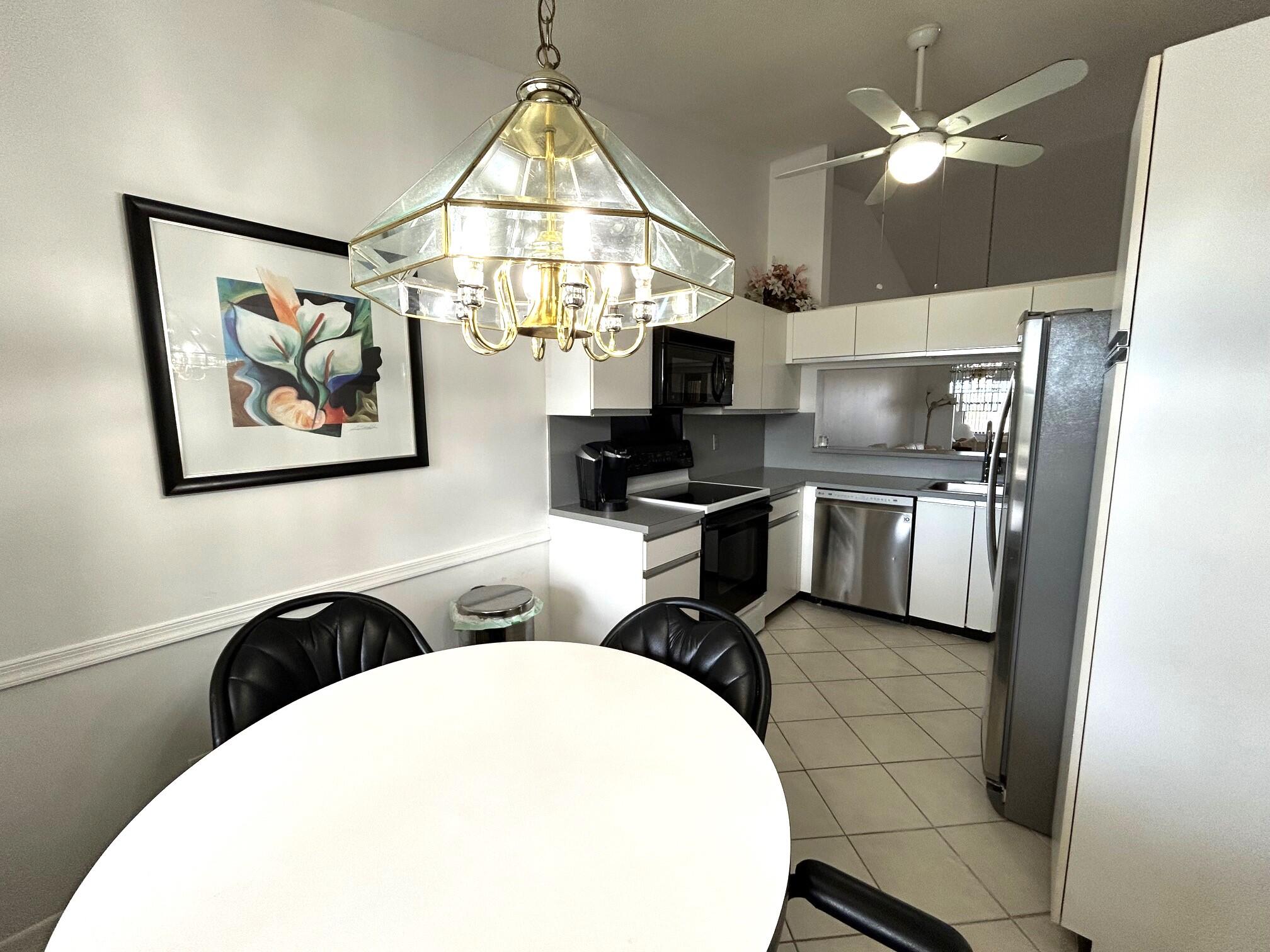 a kitchen with stainless steel appliances a stove a refrigerator and a chandelier