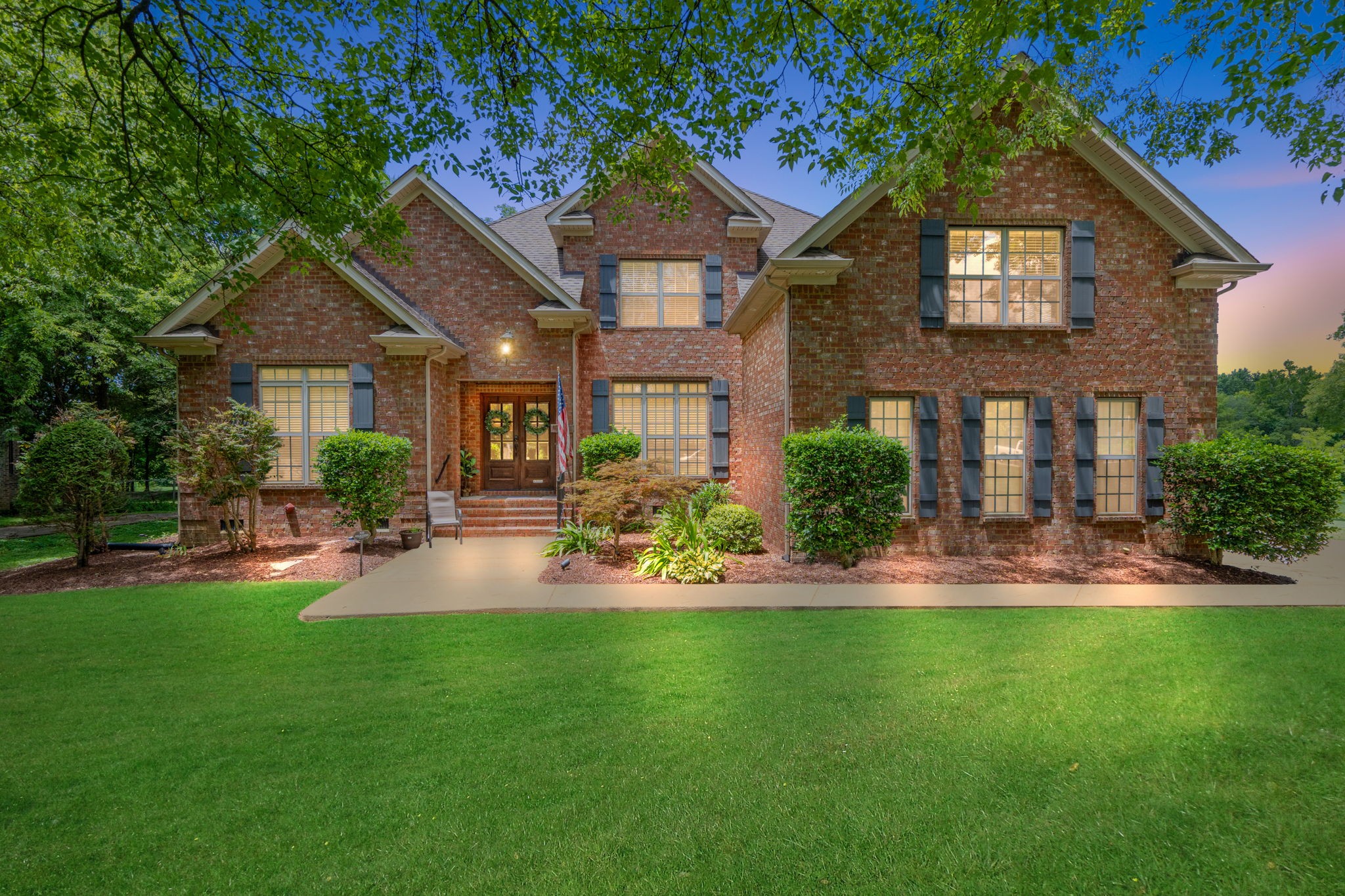 a front view of a house with swimming pool and garden