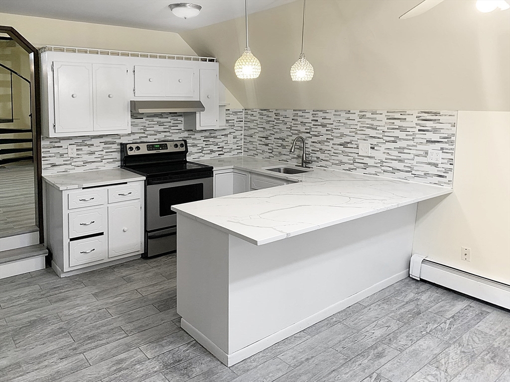 a kitchen with a sink cabinets and wooden floor