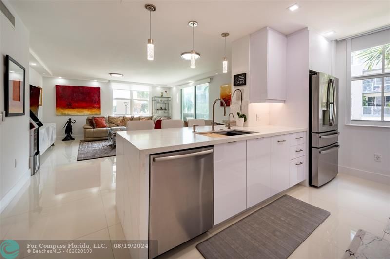 a kitchen with stainless steel appliances granite countertop a sink stove and refrigerator