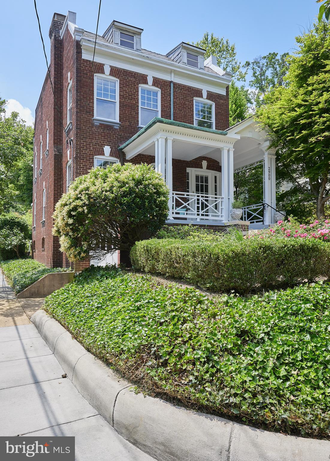 a front view of a house with a yard and potted plants