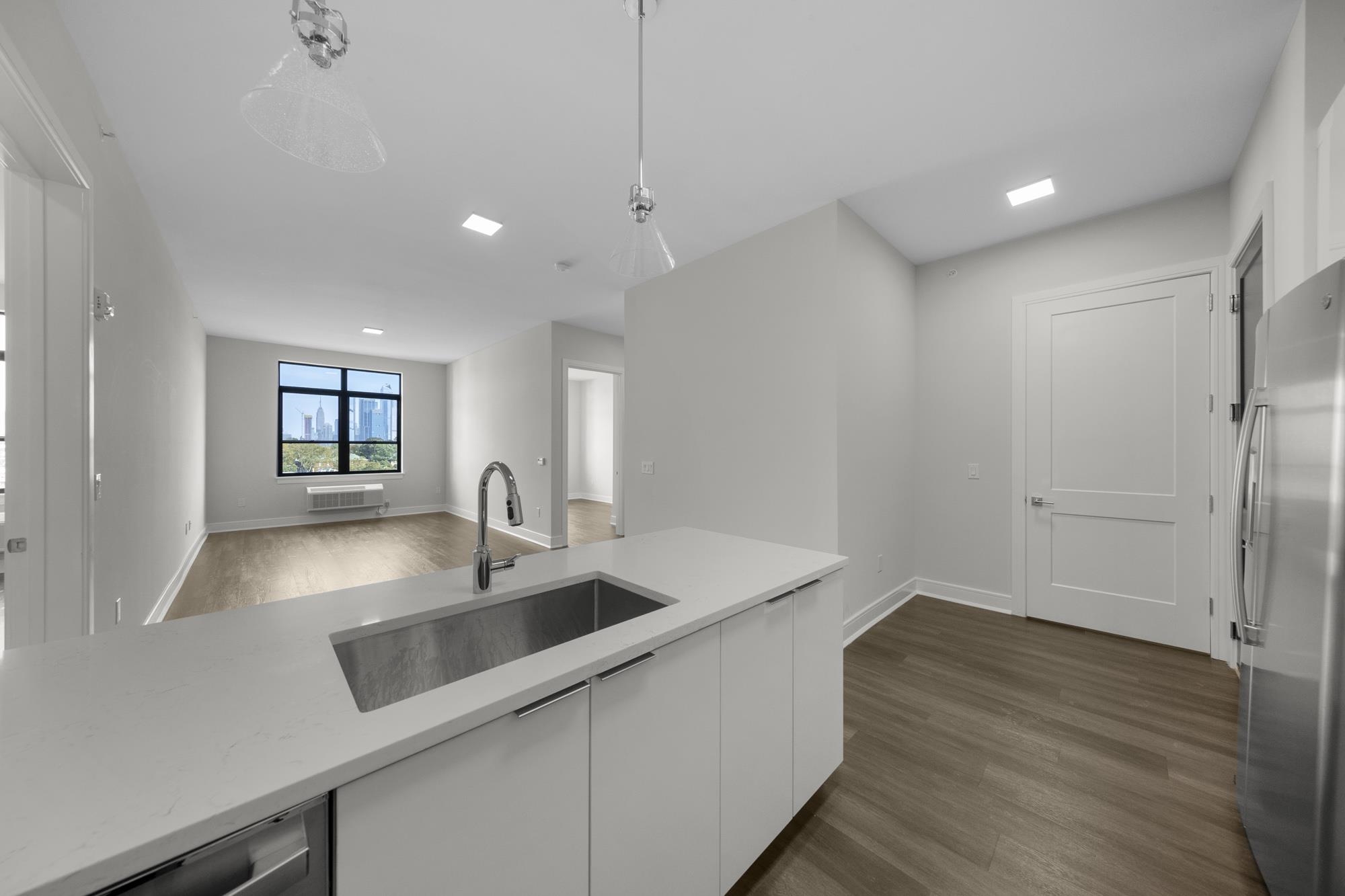 a kitchen with kitchen island a sink and a refrigerator