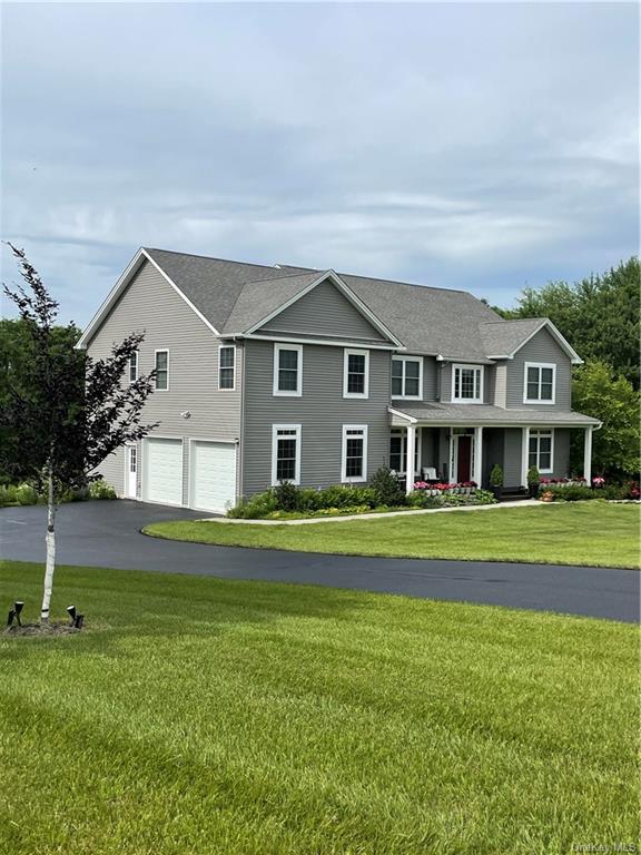 View of front of home featuring a front lawn and a garage