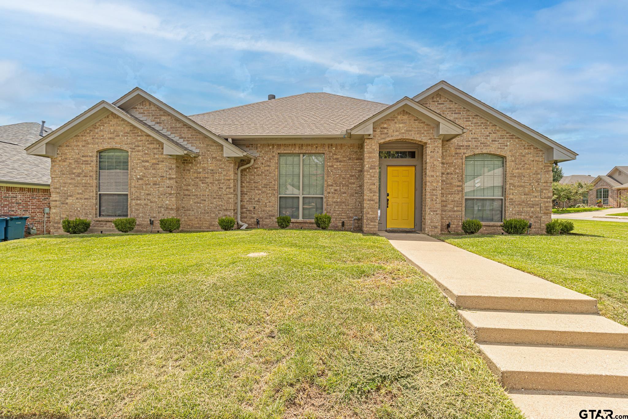 a view of a brick house with a yard