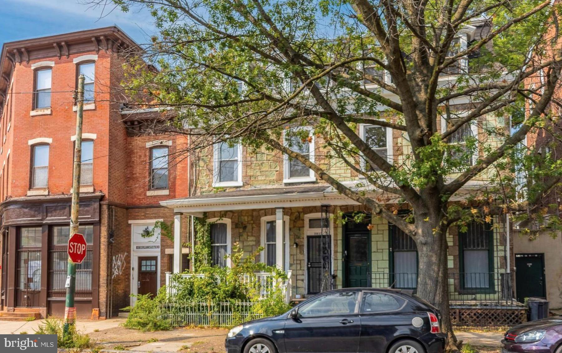 front view of a brick house with a large tree