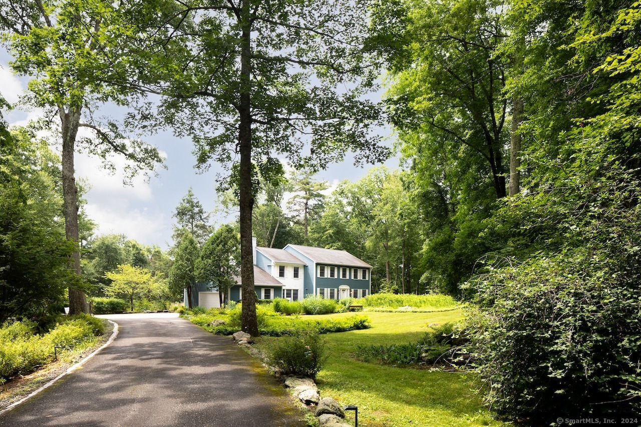 a view of a house with garden and trees