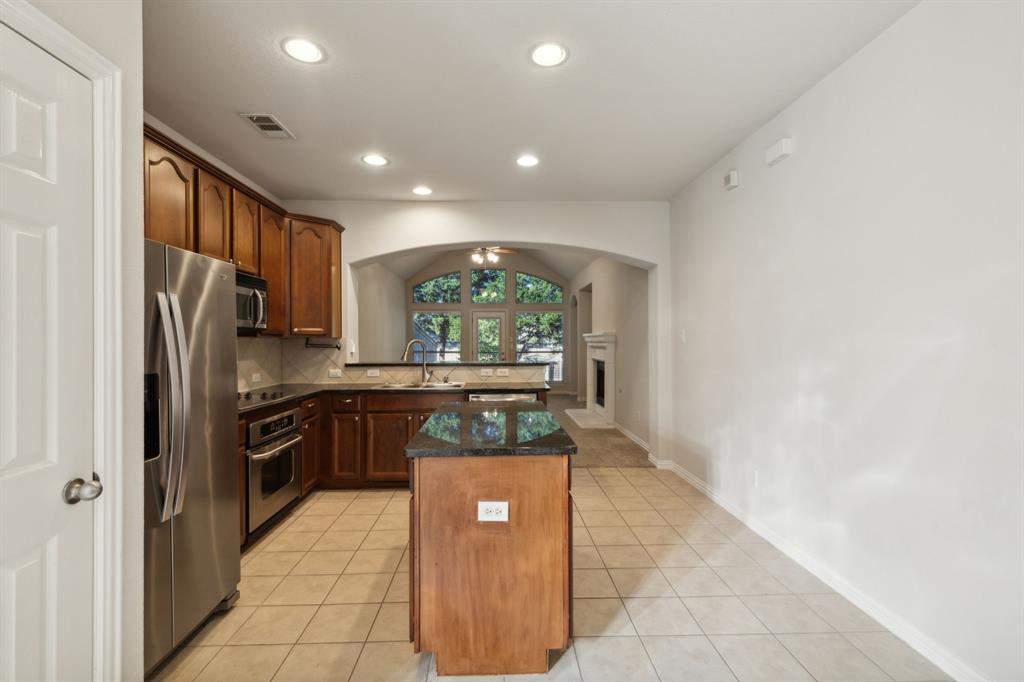 a kitchen with stainless steel appliances granite countertop a refrigerator and a stove