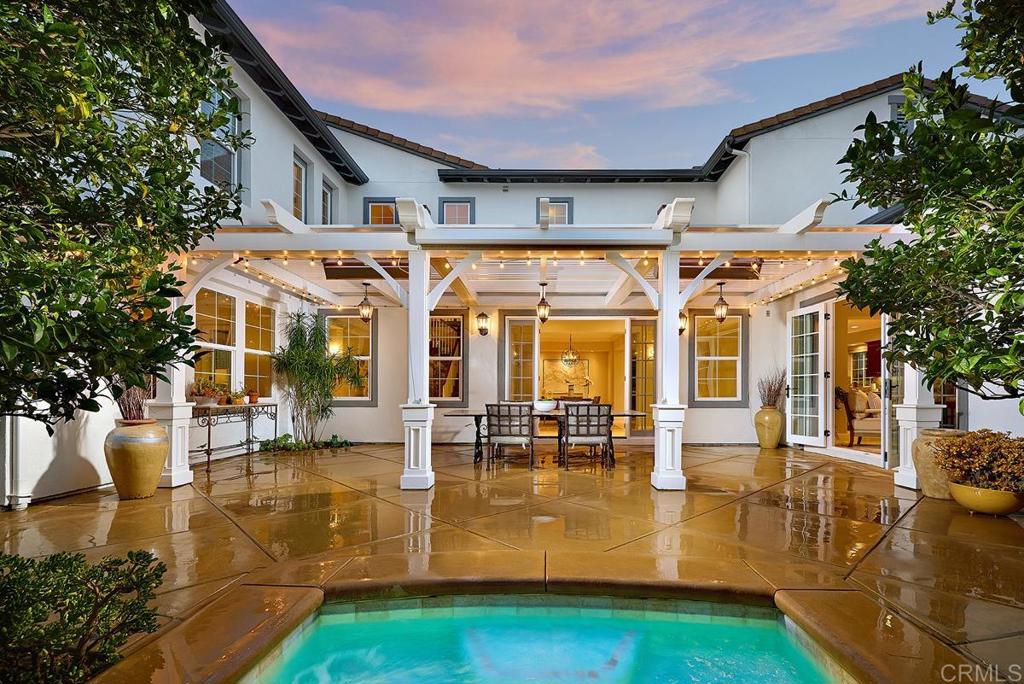 a view of a patio with couches and table potted plants and large tree