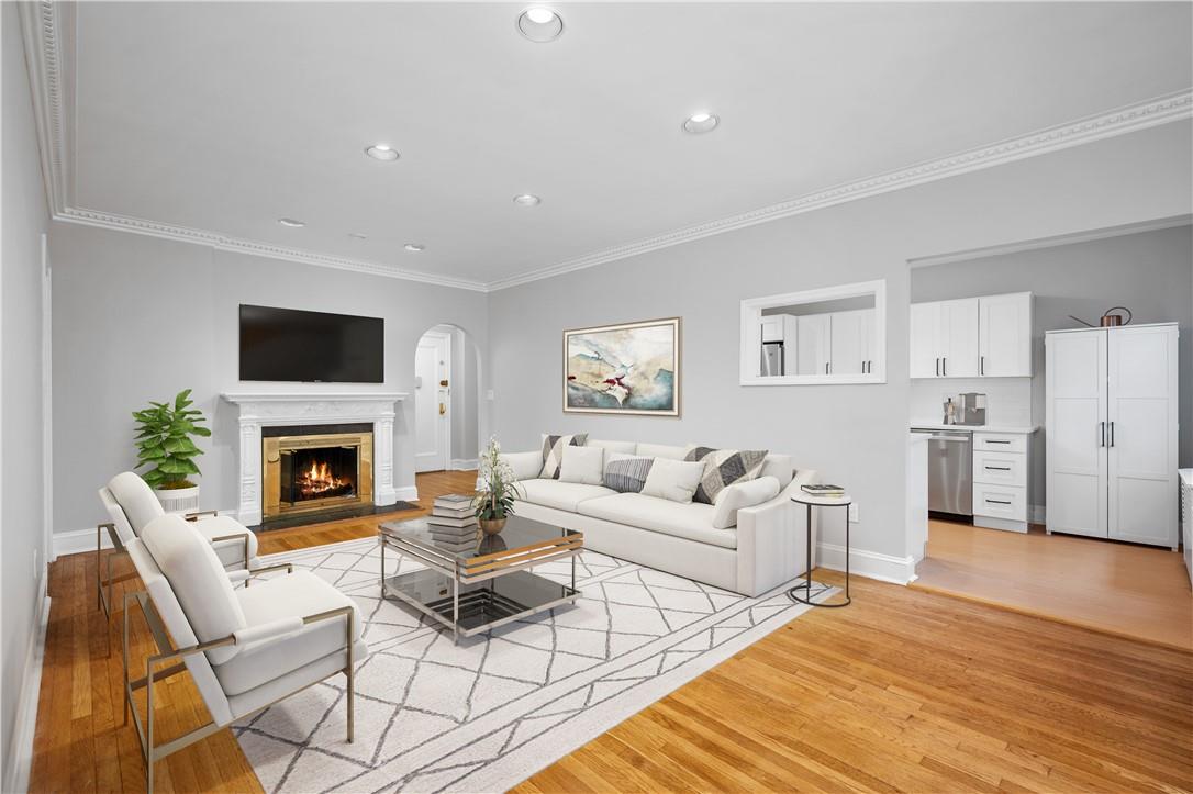 Living room with light hardwood / wood-style flooring and crown molding