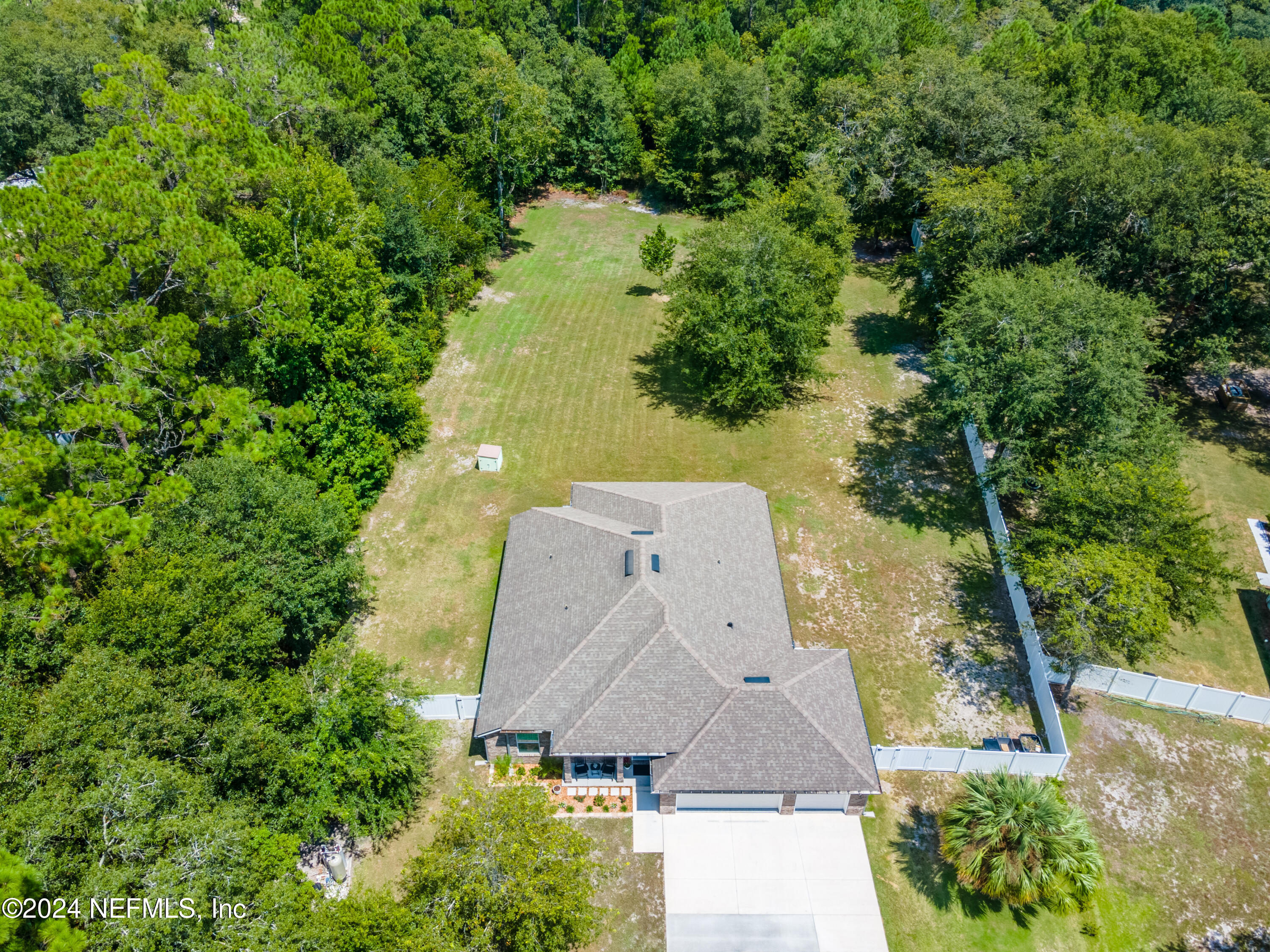 an aerial view of a house with a yard and lake view