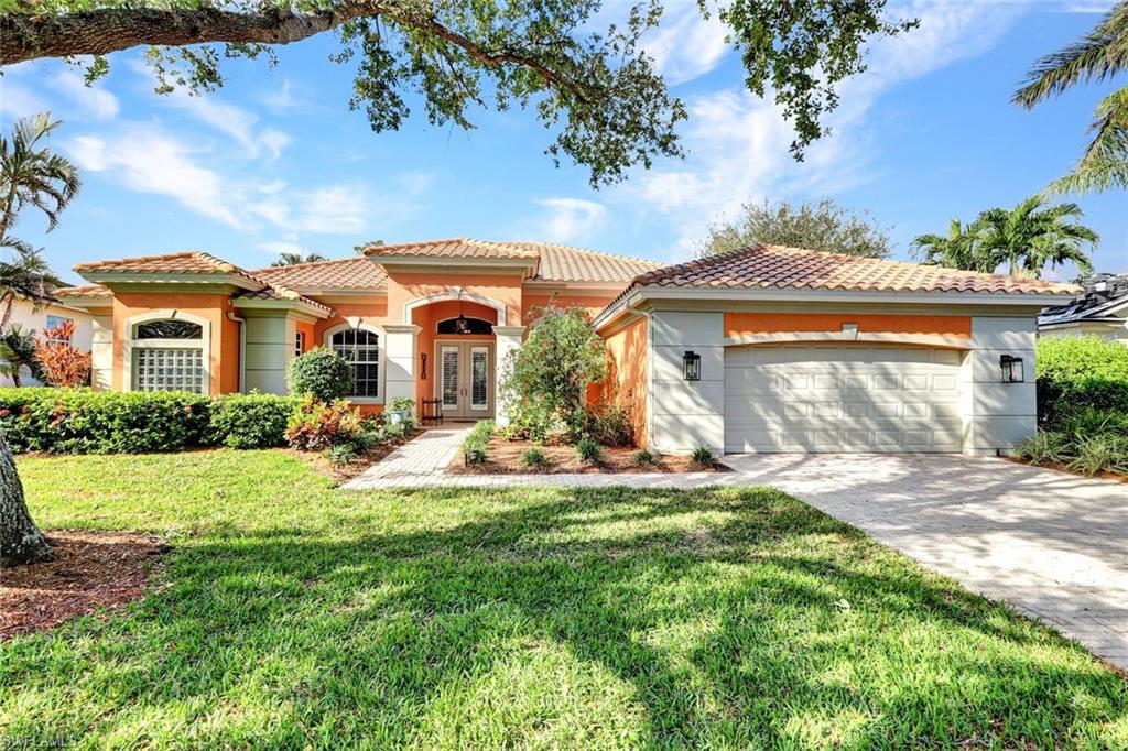 Mediterranean / spanish home featuring a front lawn, a garage, and french doors