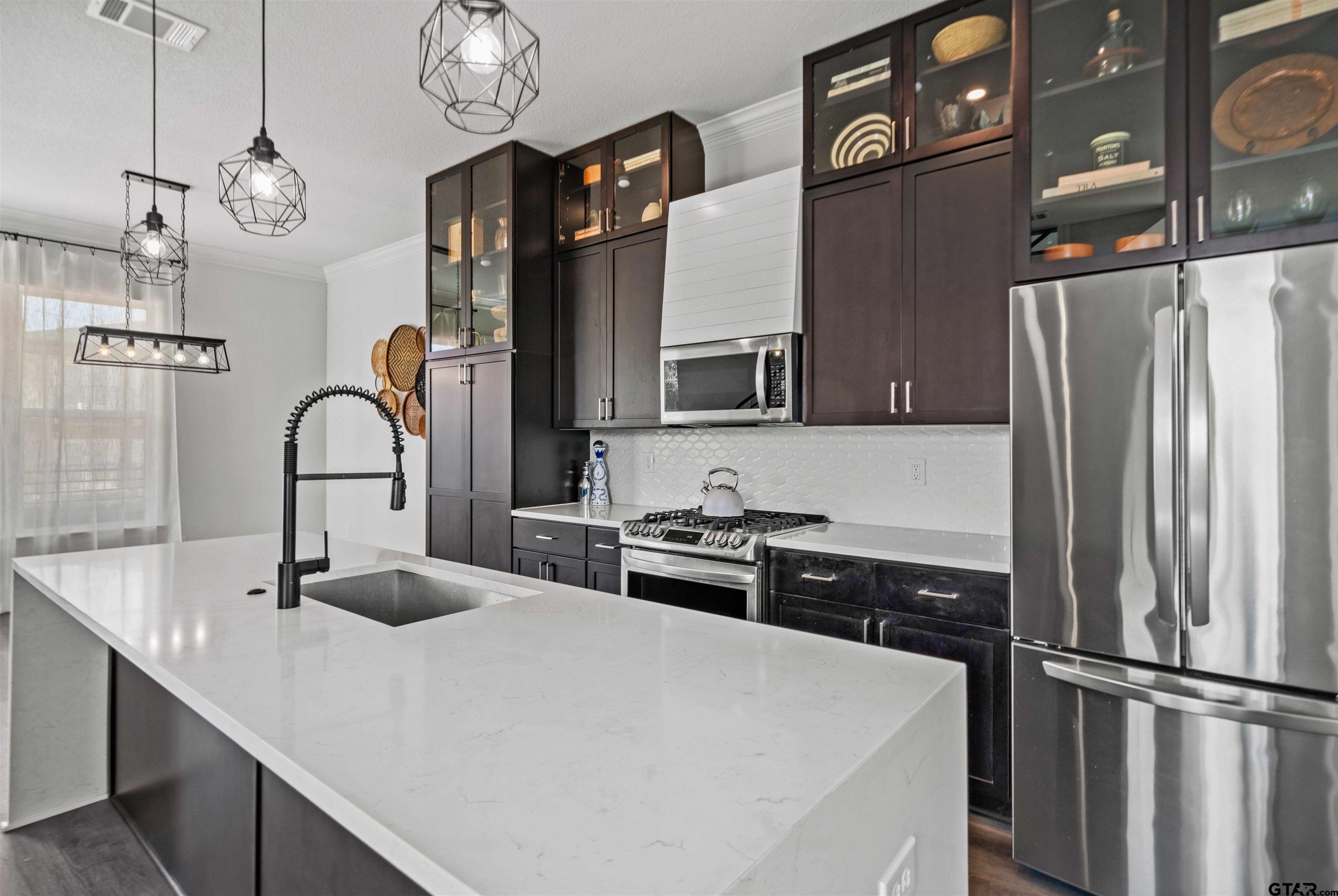 a kitchen with stainless steel appliances a sink and a refrigerator