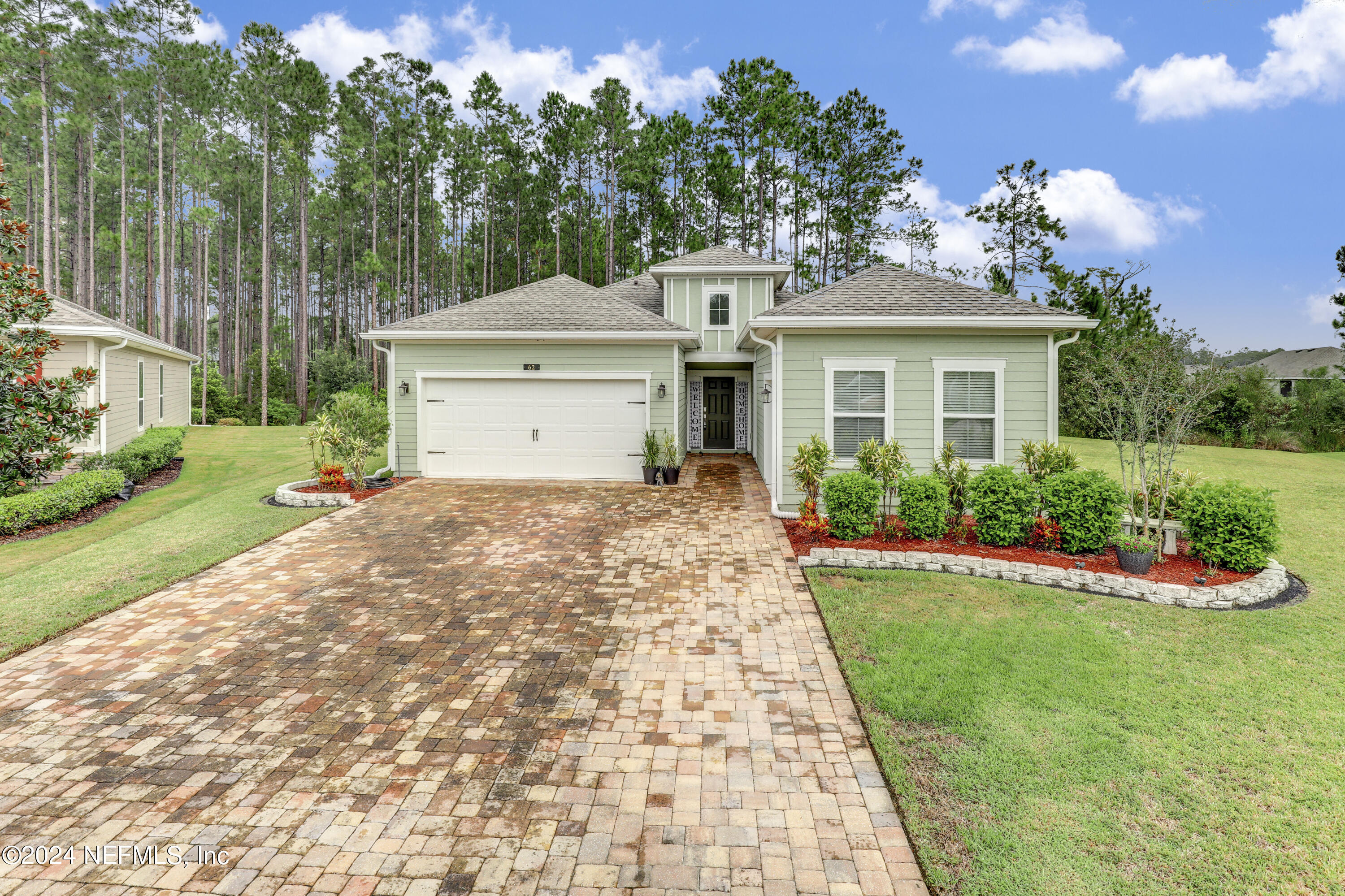 a front view of a house with a garden and yard