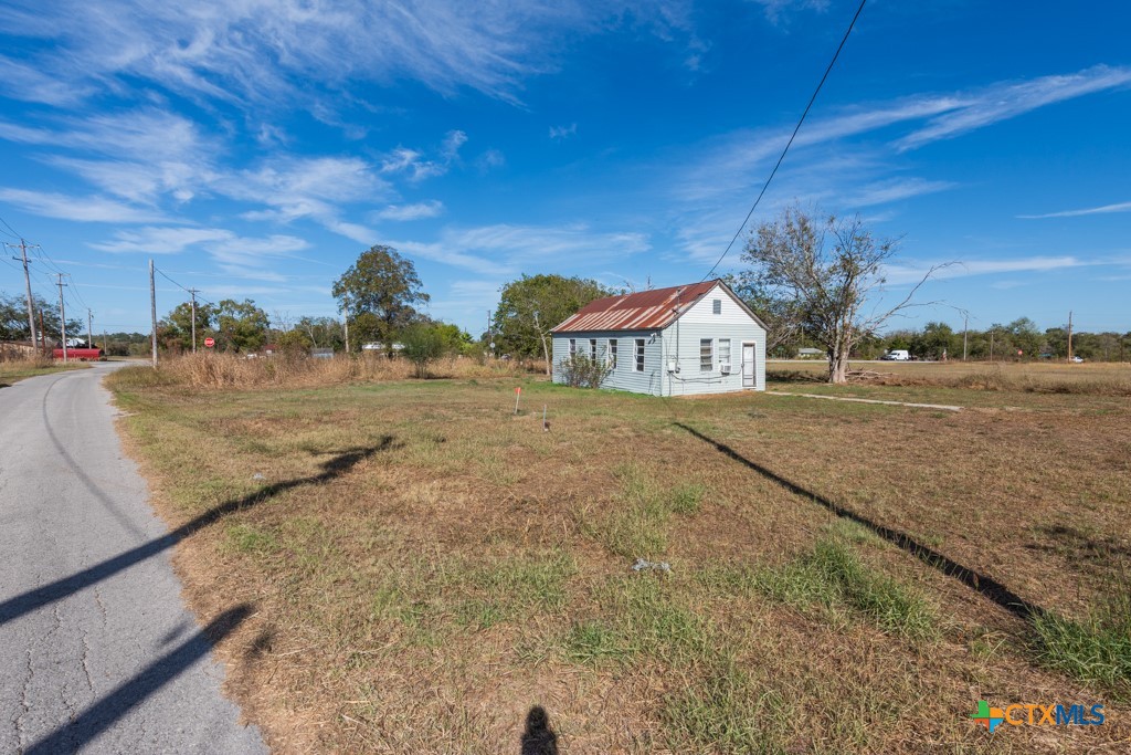 a view of a dry yard with wooden fence