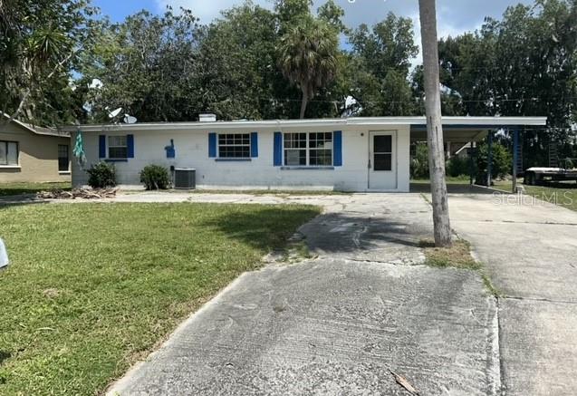 a view of a house with backyard and a tree