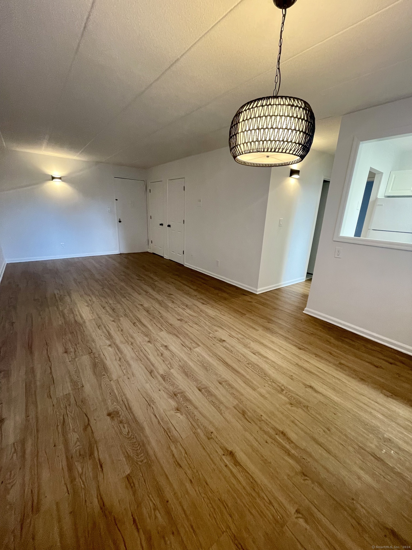 a view of a room with wooden floor and white walls