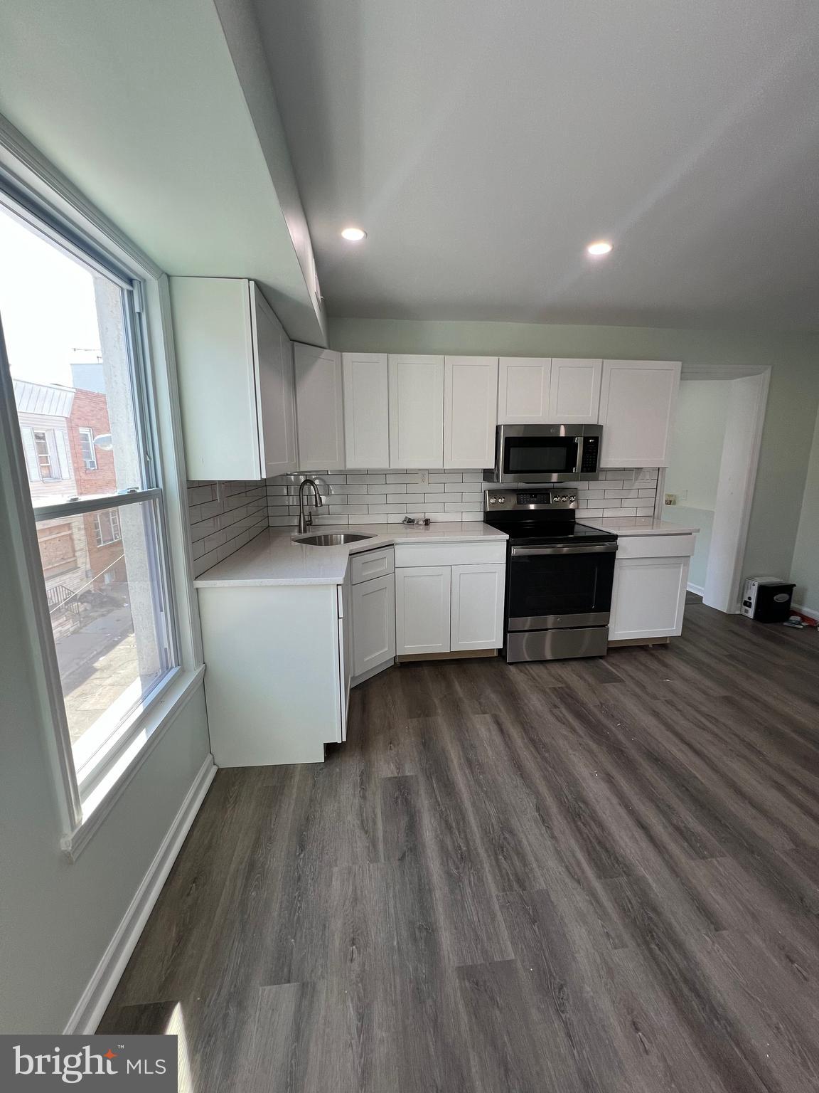 a kitchen with microwave a stove and cabinets