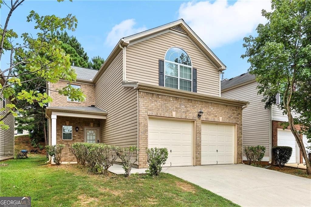 a front view of a house with a yard and garage