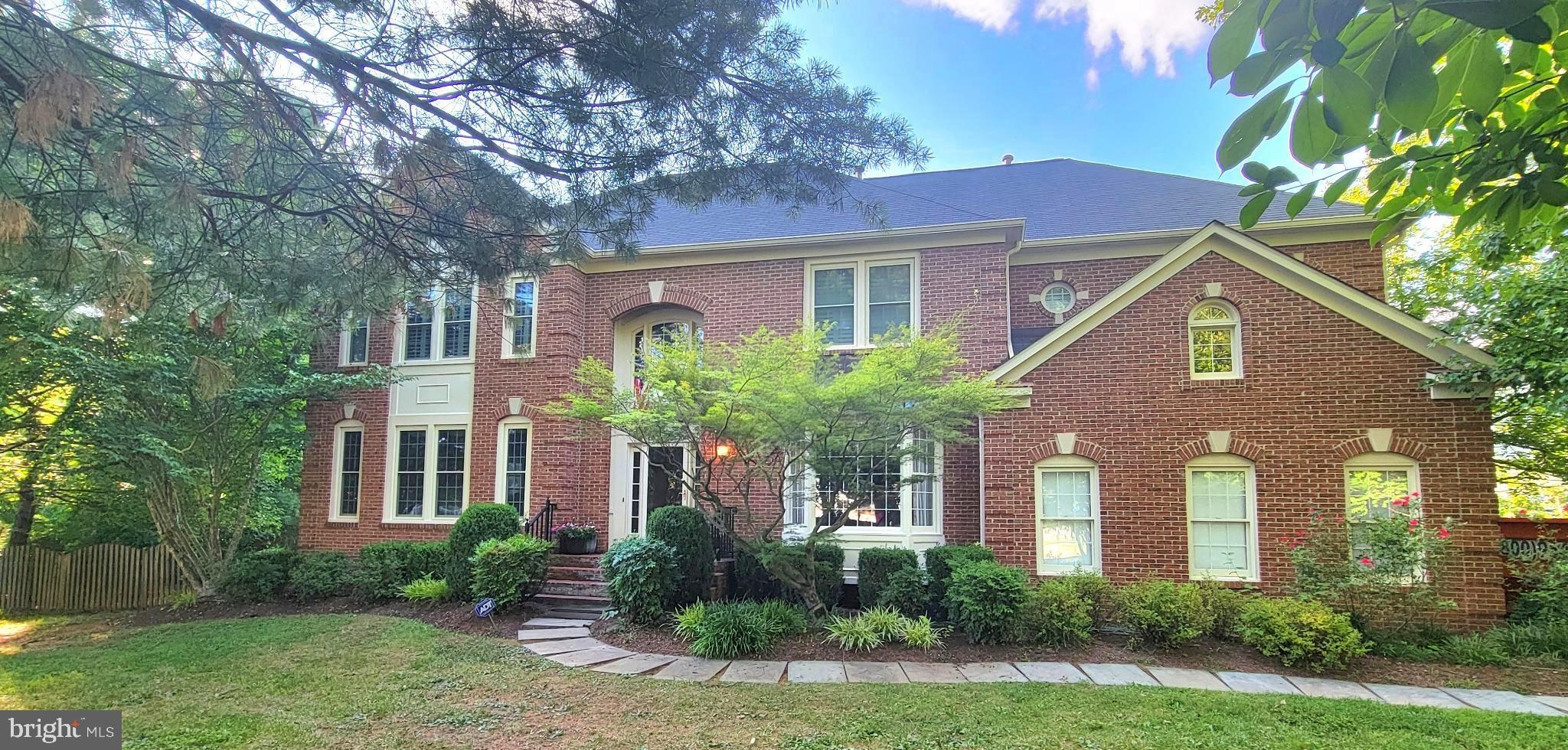 a front view of a house with yard and green space