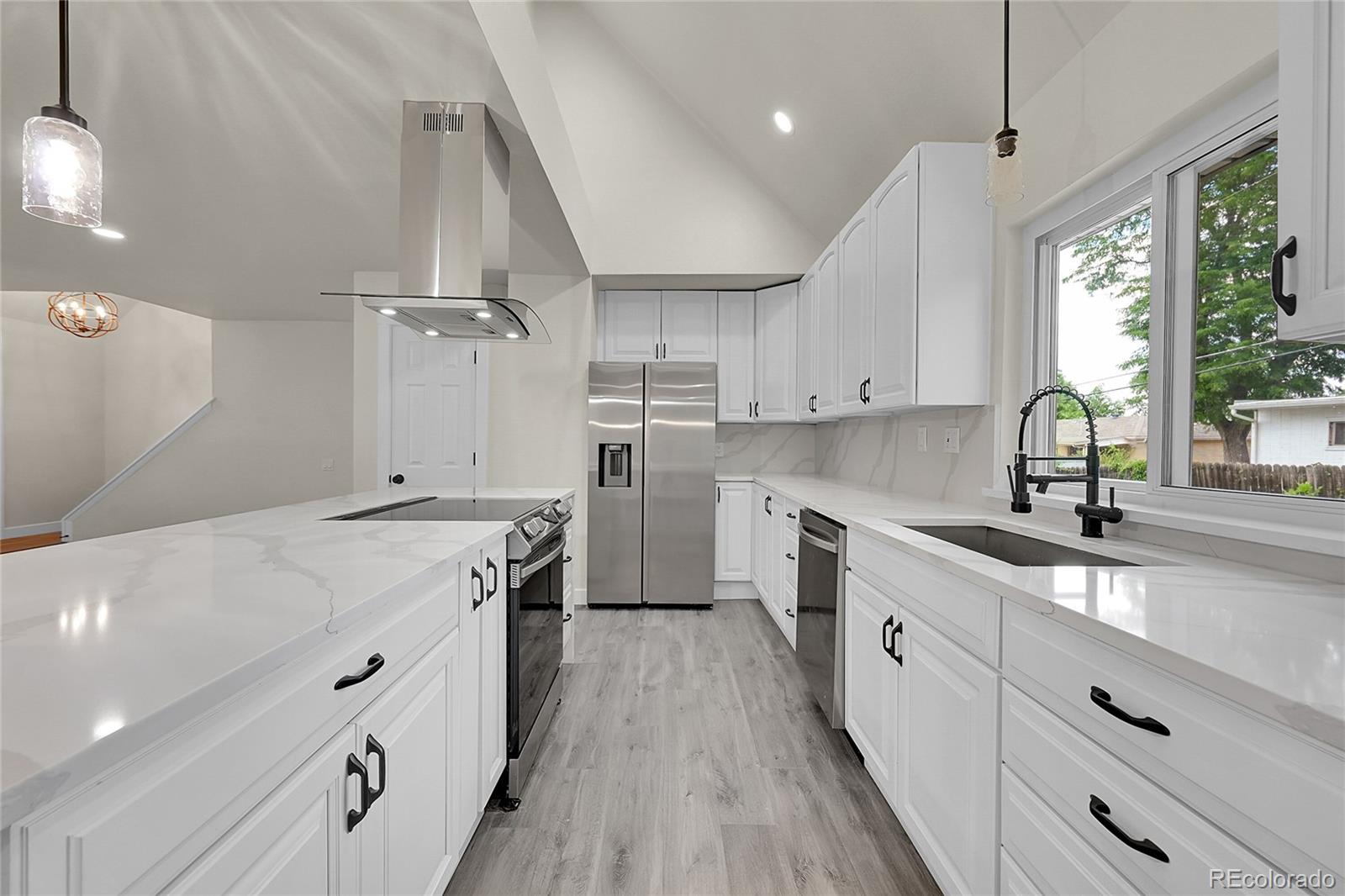 a kitchen with granite countertop a sink a counter space appliances and cabinets