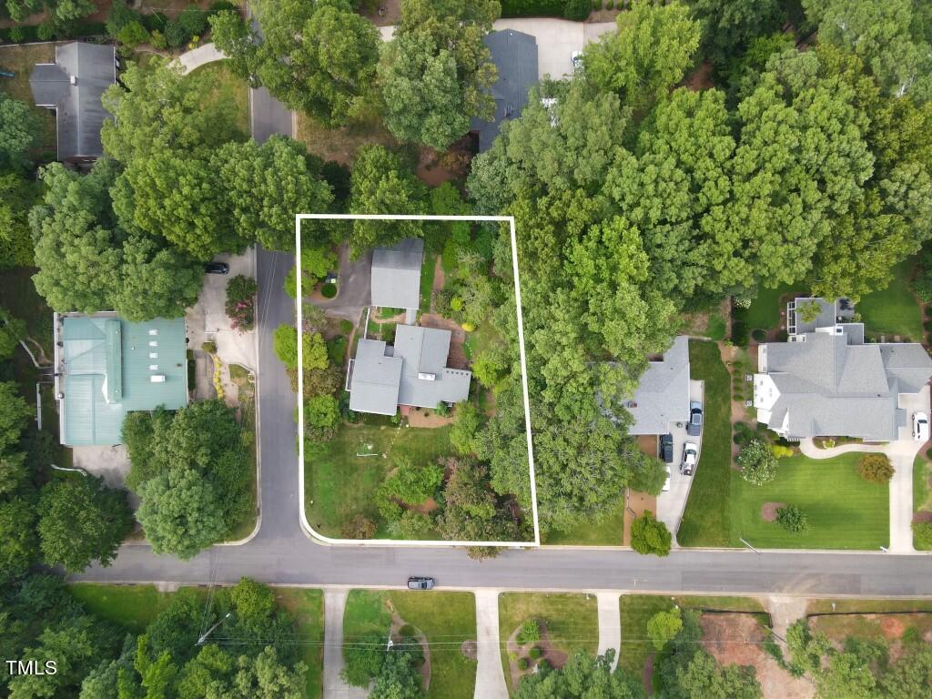 an aerial view of residential house with outdoor space and trees all around